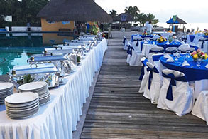 Área de buffet junto a mesas preparas para un evento en Cozumel