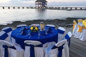 Un par de mesas listas para un banquete con vista al muelle