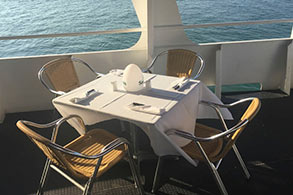 Mesa exterior dispuesta para el banquete y con vista al mar