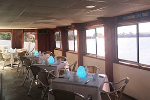 Mesas interiores prepadas para el banquete con vista al mar