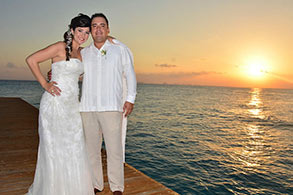 Pareja posando en el atardecer con vista al mar