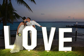 Pareja posando en un banner de LOVE en Garrafón