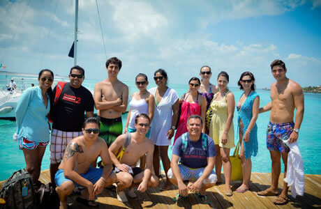 Grupo de jóvenes posando con el mar de Isla Mujeres detrás