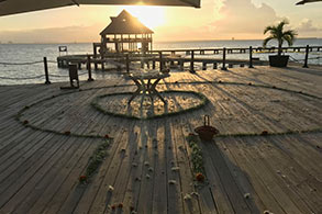 Altar con pétalos, dispuesto en un muelle para boda al atardecer